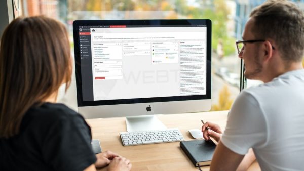 Webtop: Homem e Mulher a consultar ecrã de boas vindas no Dashboard do backoffice (desktop inserido em um setup minimalista)